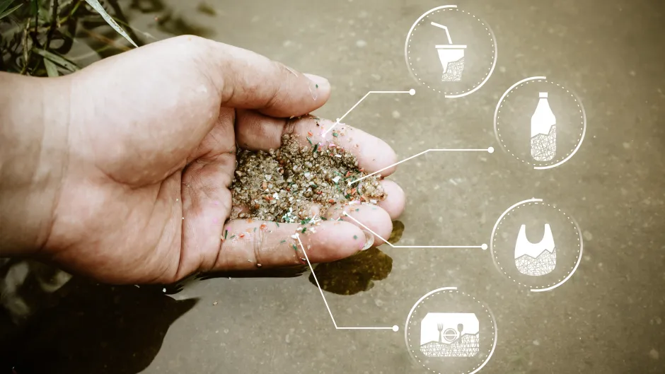 Menschliche Hand mit einer Mischung aus Sand und Plastikteilchen sowie erklärende Grafik, woher diese ursprünglich stammen